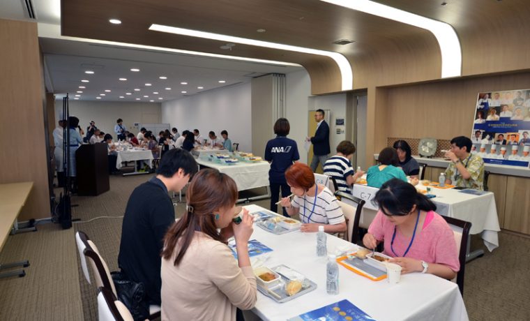 7月29日には、ANAの機内食を製造しているANAC（ANAケータリングサービス）川崎工場では抽選で選ばれた37名が機内食工場見学＆2次選挙ノミネート機内食の試食を楽しんだ。